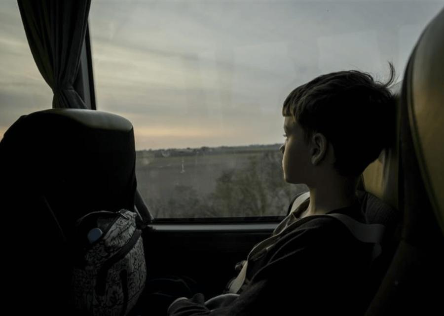 bambino su autobus che guarda dal finestrino 