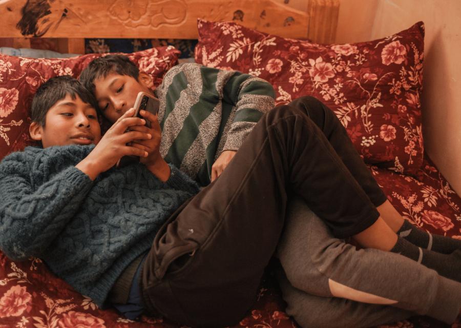 Ragazzi sdraiati sul letto con cellulare in mano