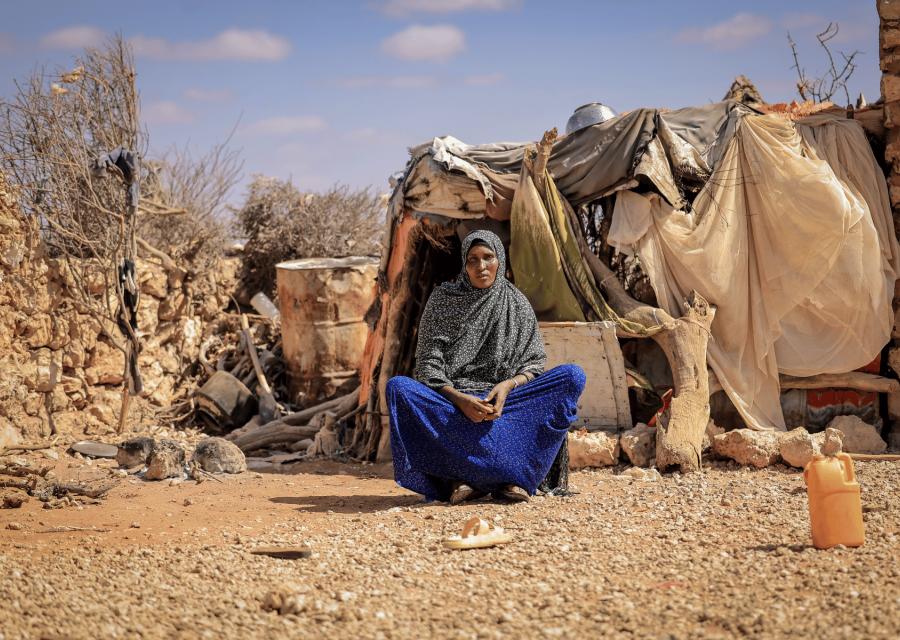 Donna seduta per terra davanti alla sua casa in Somalia