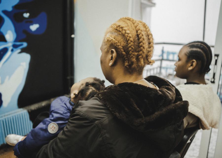 Una mamma seduta con le sue due figlie di 11 anni e di 16 mesi.