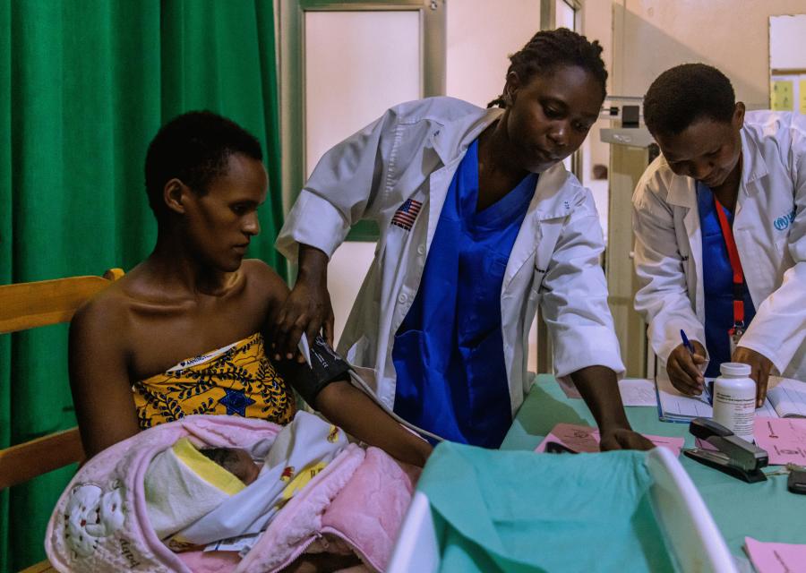 Operatrici sanitarie di Save the Children che misurano la pressione al braccio ad una donna