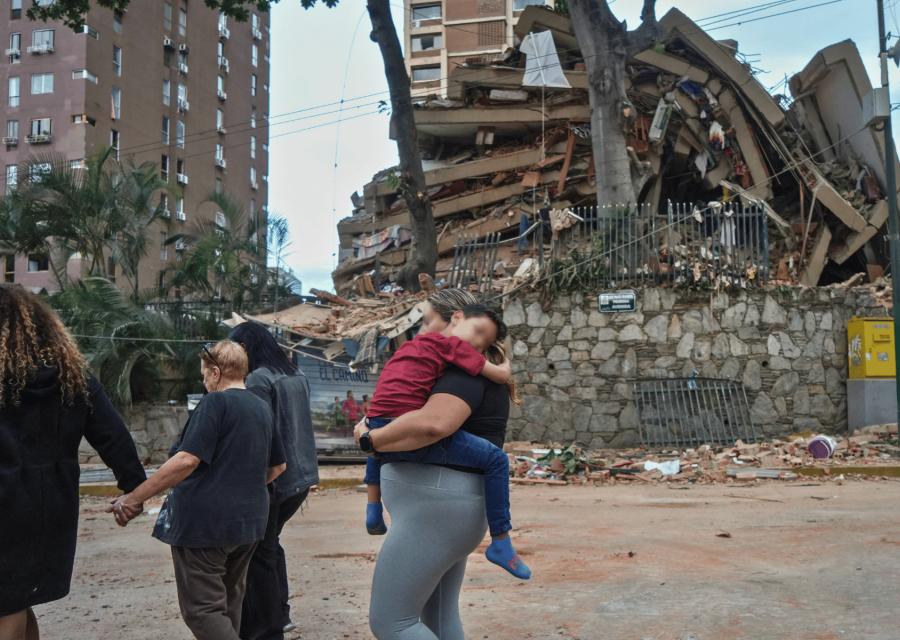 Bambino in braccio alla mamma in mezzo alle macerie dopo il terremoto in Venezuela.