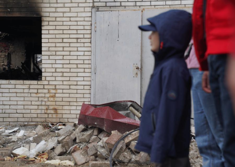 Sagoma bambino di fronte a distruzione a causa della guerra in Ucraina.
