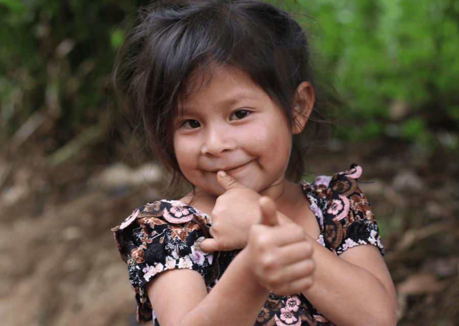 Bambina che sorride e fa gesti con le mani