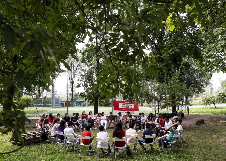 gruppo di bambini seduti in cerchio all'aperto