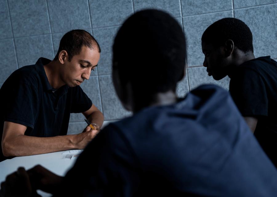 Un operatore che parla con due minori migranti