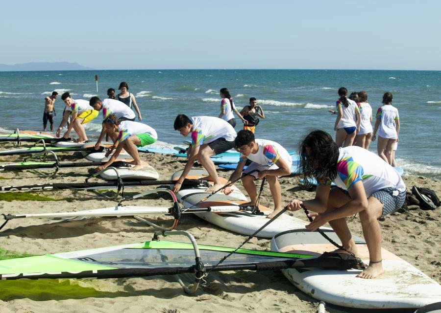 bambini in spiaggia si esercitano in wind surf