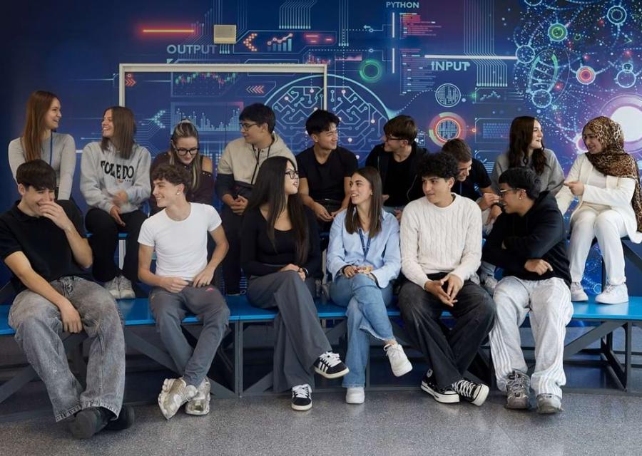 gruppo di adolescenti seduti sui banchi con sfondo murales