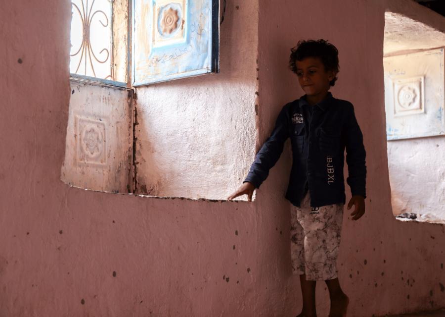 Bambino nella sua casa vicino alla finestra.