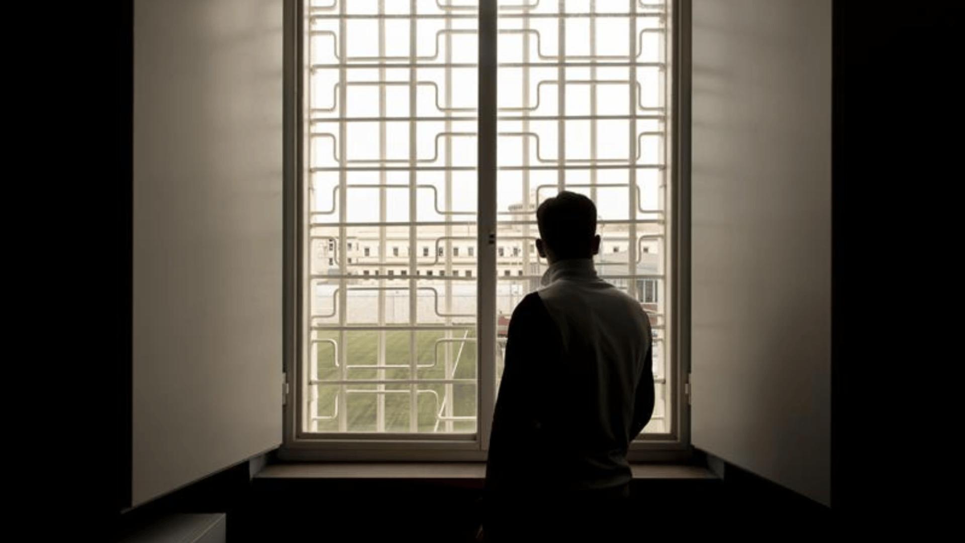 Ragazzo di spalle di fronte ad una finestra