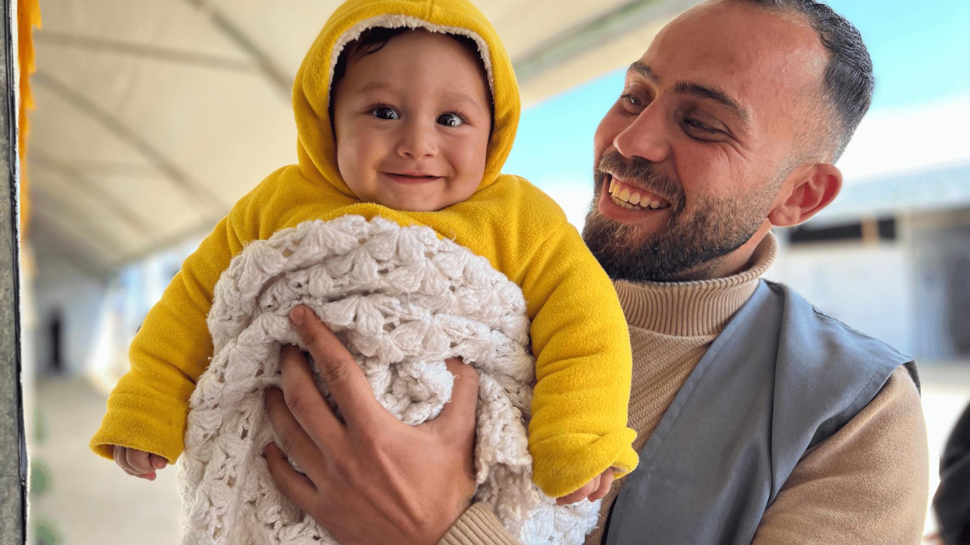  Sameer, 6 mesi, con Ali, staff di Save the Children, durante la distribuzione di kit per bambini a Gaza