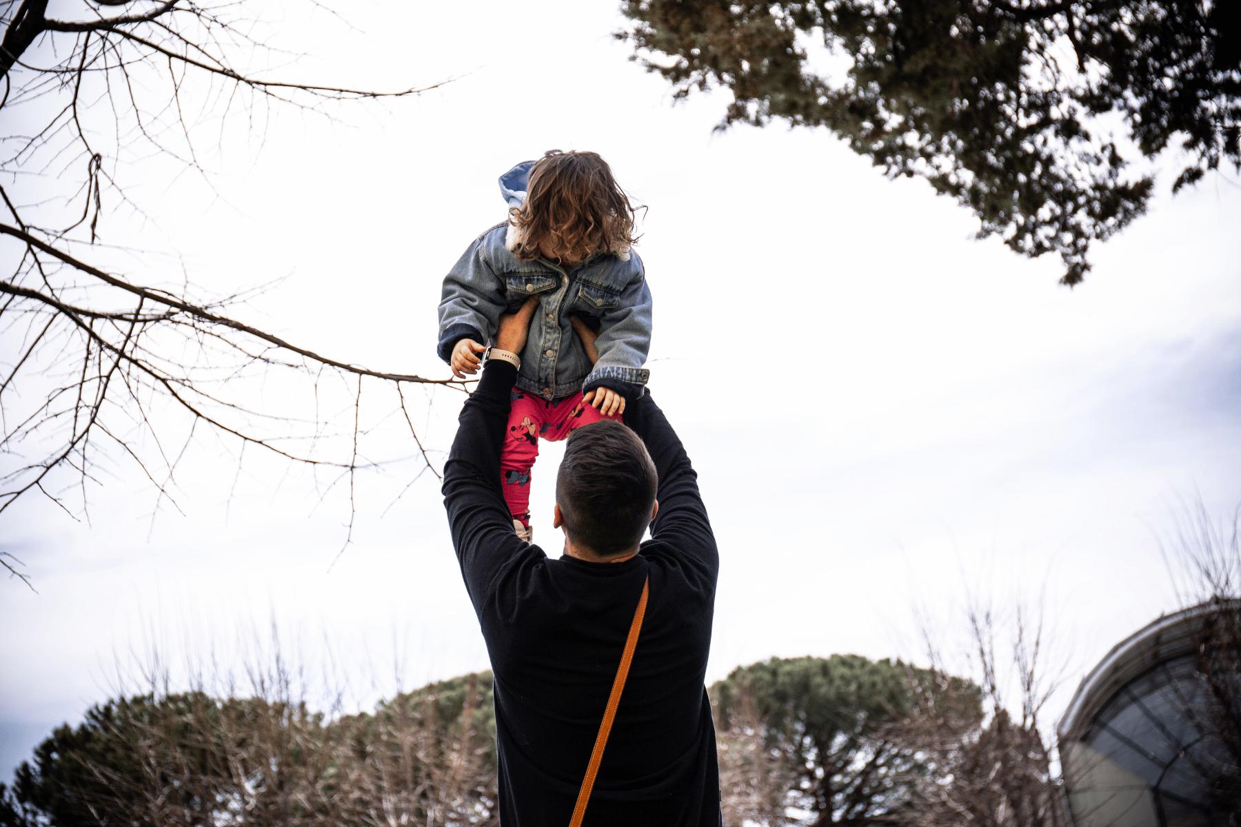 Padre che prende in braccio la propria figlia 