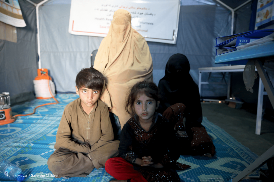 bambini e donne in Afghanistan seduti su tappeto