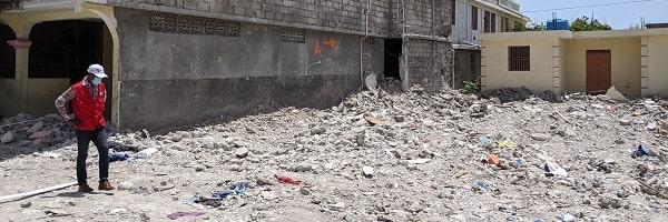 Un operatore di Save the Children guarda le macerie di una casa crollata durante il terremoto del 2021.