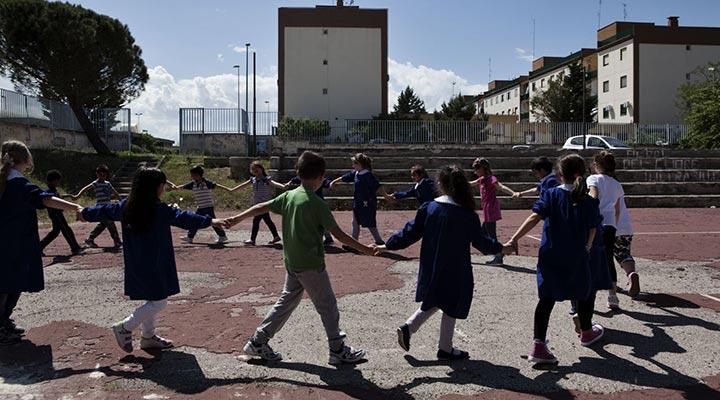 Bambini in cerchio giocano al girotondo in un parco