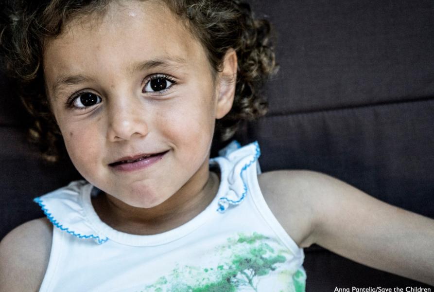 primo piano bambino sorridente con occhi scuri e capelli castani