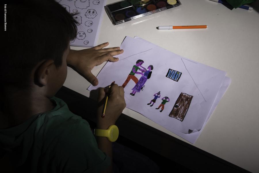Bambino in camera disegna alla scrivania