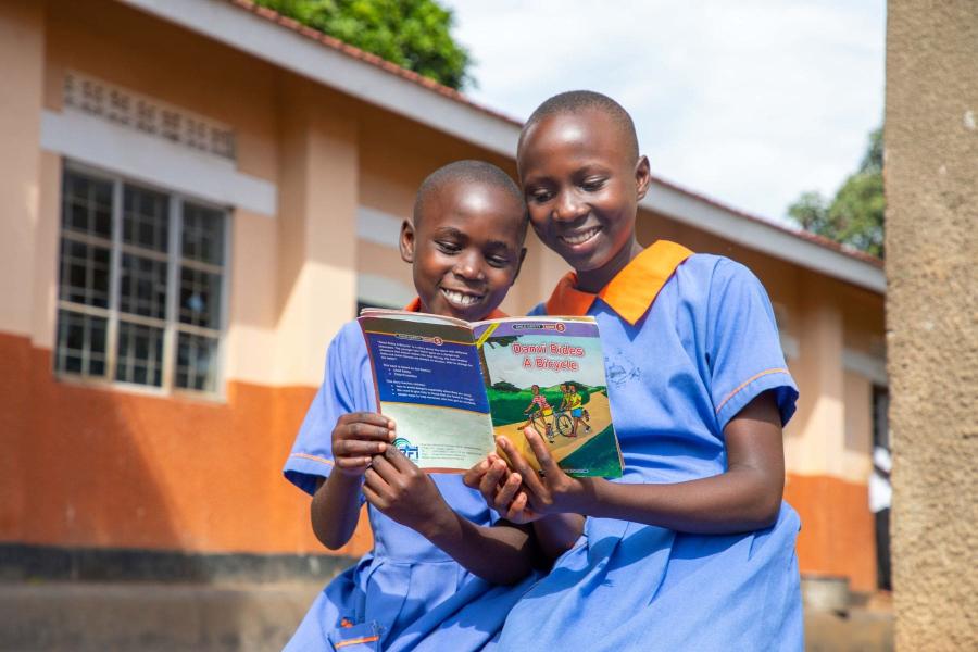 due bambine in divisa scolastica leggono un libro
