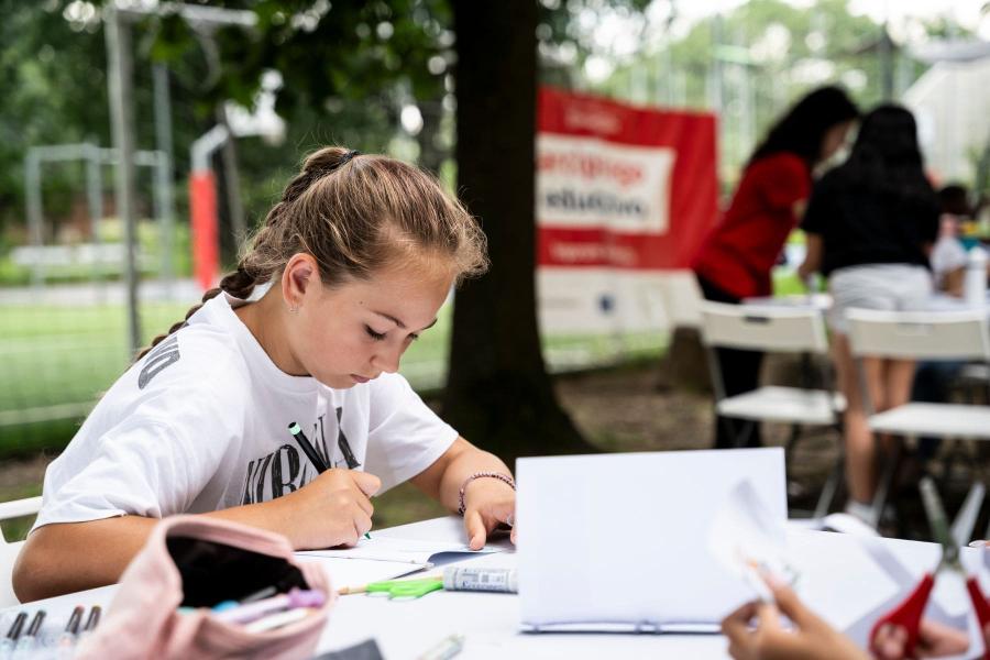 una ragazza scrive su un quaderno